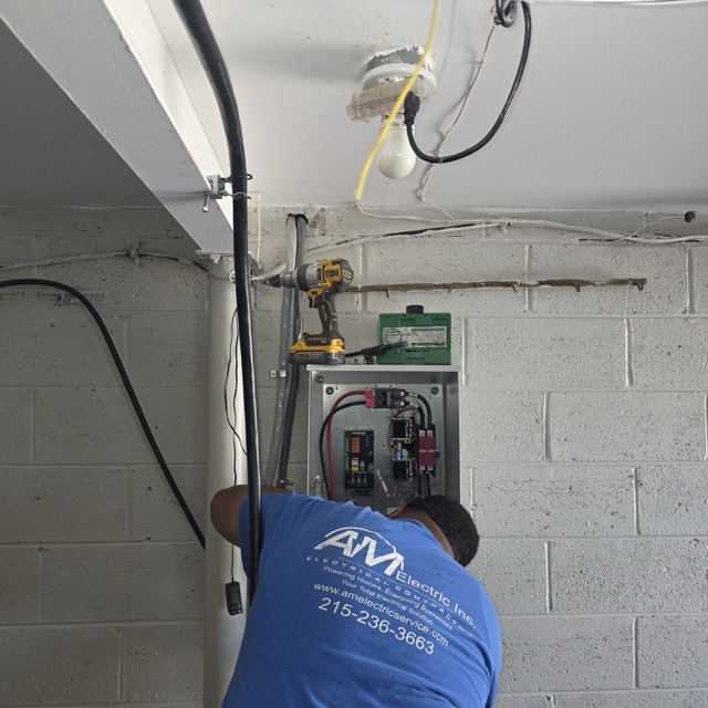 AM Electric electrician wiring the generator transfer switch box inside basement